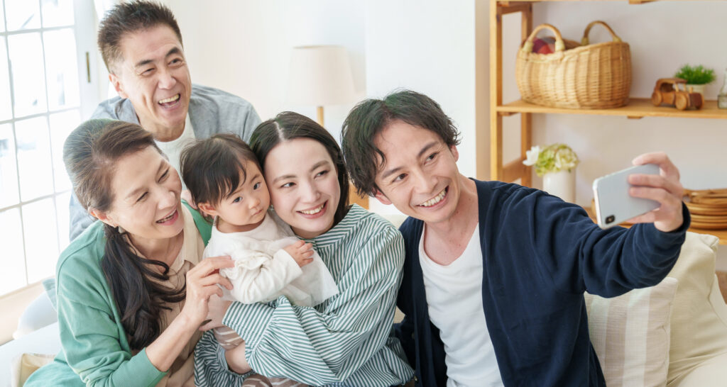 スマートフォンで笑顔の家族写真を撮る