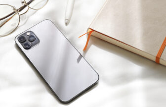 優しい日差しを受けるスマートフォンと日記と眼鏡