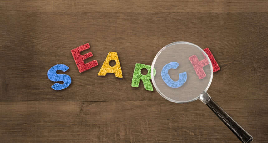 積み木のアルファベットでSEARCHの文字を虫眼鏡で除いている様子