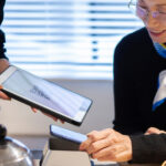 カフェでキャッシュレス決済をしているシニア女性
