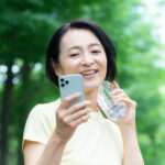 スマートフォンを片手にウォーキングをするミドル女性