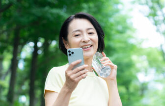 スマートフォンを片手にウォーキングをするミドル女性
