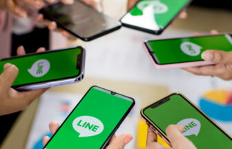 スマートフォンでLINEの画面を見せ合うシーン
