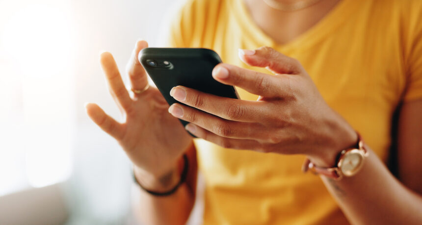 スマートフォンで文字を入力する女性の手元