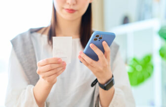 スマートフォンで家計簿を管理する女性