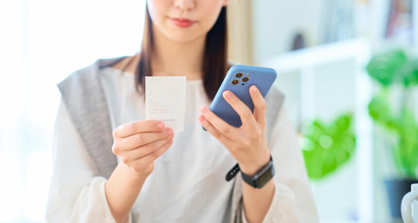スマートフォンで家計簿を管理する女性