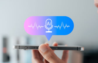 手にスマートフォンを持って声でAIアシスタントを使っているイメージ