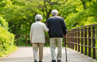 幸せそうに自然の中を散歩する老夫婦のバックショット