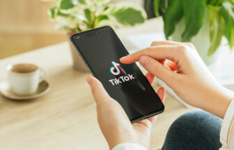 スマートフォンでTIKTOKを見ている女性