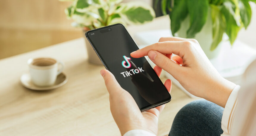 スマートフォンでTIKTOKを見ている女性