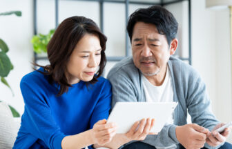 シニア夫婦が自宅のソファに座り老後の話をしている様子