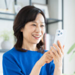 スマートフォンを楽しそうに見ている日本人女性