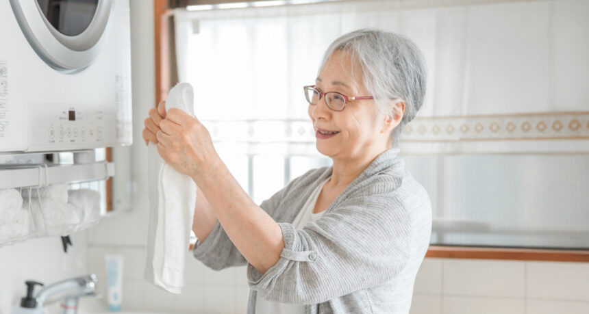 主婦が洗濯機から洗濯物を取り出している様子