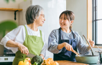 キッチンで孫と一緒に調理を楽しむ祖母